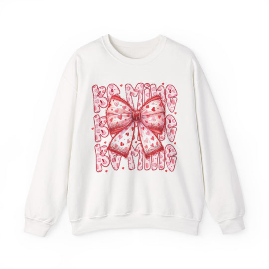 Be Mine Crew sweatshirt featuring a large pink-and-red bow with heart motifs, set against playful Valentine-themed lettering, embodying festive, stylish comfort.