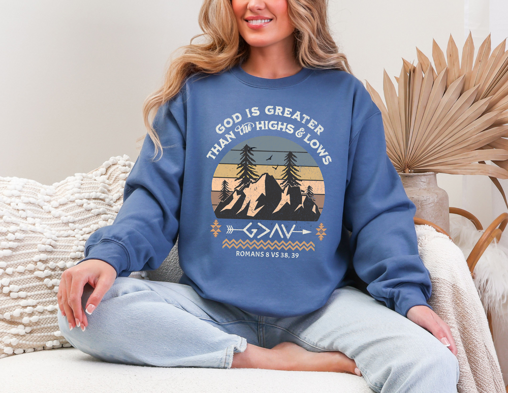 Woman seated wearing God Is Greater Crew sweatshirt, showcasing its comfortable fit and ribbed collar, ideal for casual wear.