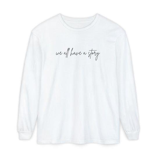 We all have a Story Long Sleeve Tee: A white, long-sleeved shirt featuring black text, crafted from 100% ring-spun cotton for a relaxed fit and comfort.
