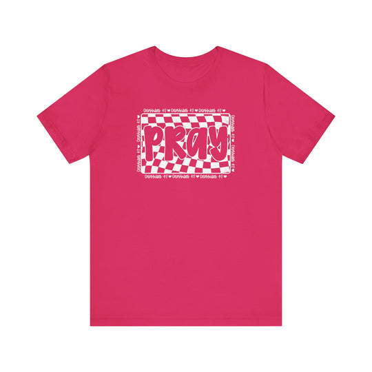 Pray Tee: Pink t-shirt featuring white text with a checkered pattern, made from soft cotton for comfort. Ideal for a casual, trendy look.