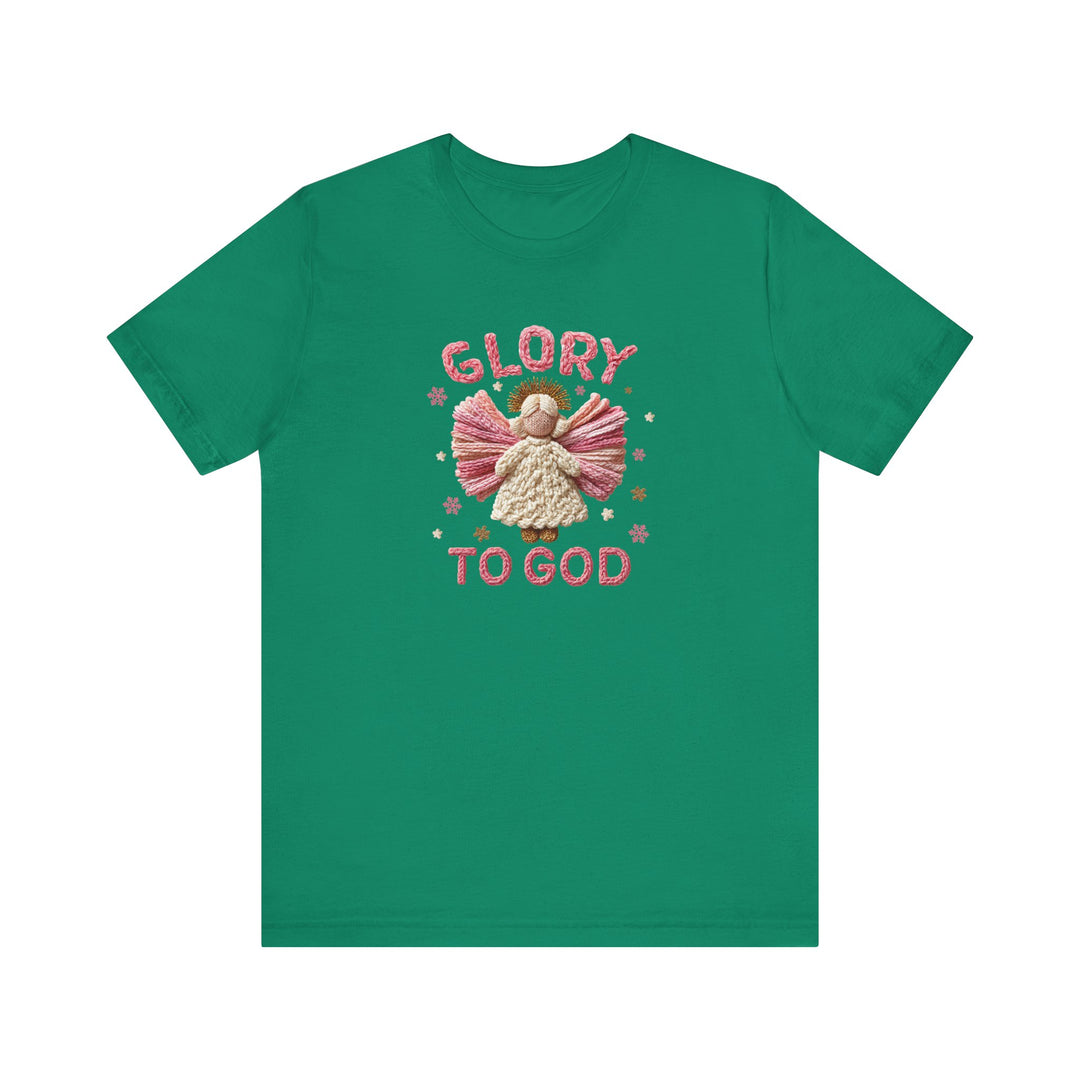 Green Glory to God Tee featuring a yarn-like angel graphic with pink wings, cream gown, and golden halo, surrounded by star shapes, emphasizing holiday spirit.