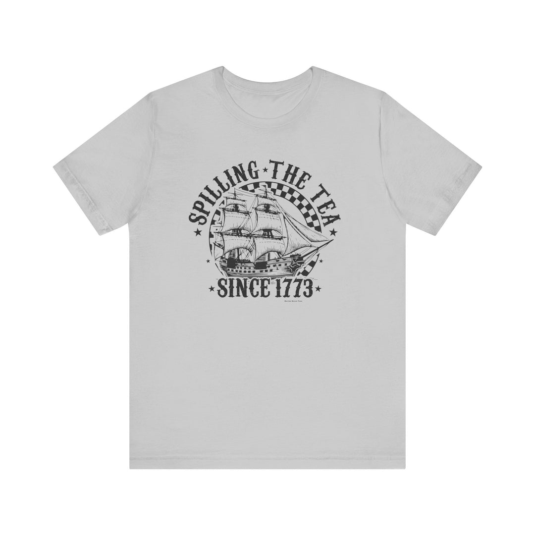 A classic white t-shirt featuring a ship graphic and text, embodying the Spilling the Tea Since 1773 Tee. Unisex fit, 100% cotton, ribbed knit collars, tear away label, and retail fit.