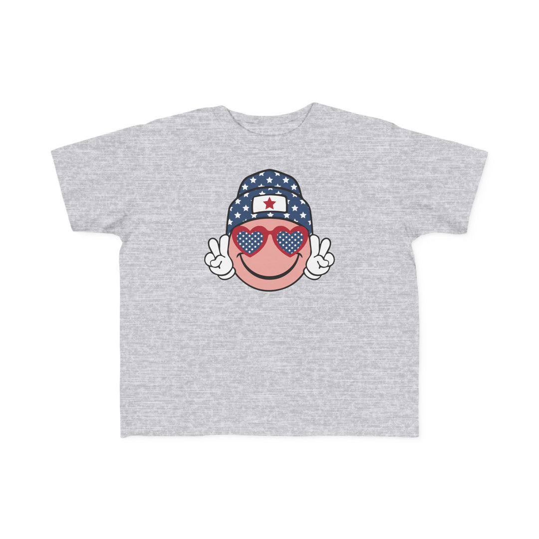 American Girl Toddler Tee featuring a grey cartoon face with sunglasses and a hat. Soft 100% combed ringspun cotton, light fabric, classic fit, tear-away label. Available in sizes 2T to 5-6T.