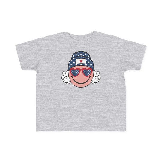 American Girl Toddler Tee featuring a grey cartoon face with sunglasses and a hat. Soft 100% combed ringspun cotton, light fabric, classic fit, tear-away label. Available in sizes 2T to 5-6T.