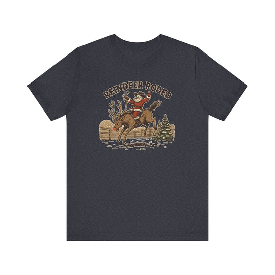 Reindeer Rodeo Tee: Vintage-style graphic of Santa riding a reindeer, complete with lasso, on a dark-charcoal crew-neck T-shirt. Soft, unisex fit.