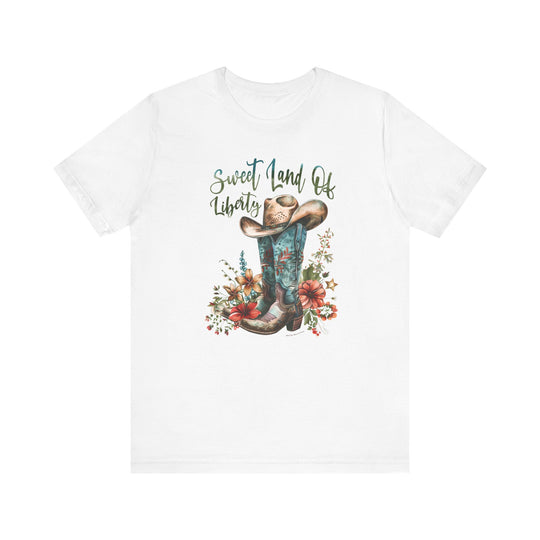 A white t-shirt featuring a cowboy hat and boots, embodying a classic American style. Unisex jersey tee made of 100% cotton, with ribbed knit collars and taping on shoulders for a comfortable fit. Sizes XS to 3XL available.