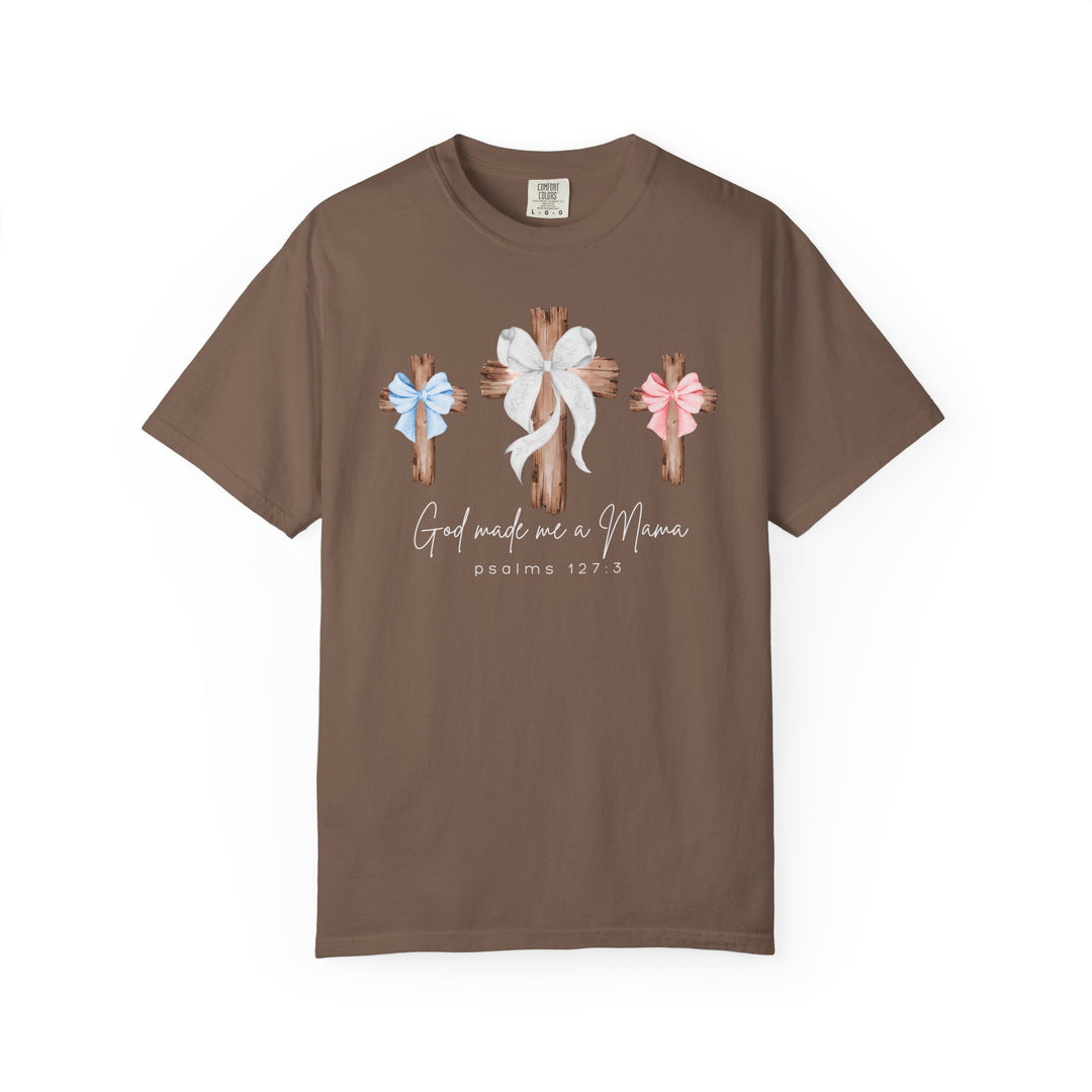 Brown “God Made Me a Mama” T-shirt with rustic wooden cross graphics and bows, featuring a Christian motherhood theme and Psalms 127:3 reference.