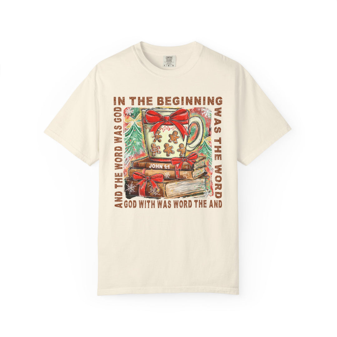 In the Beginning Tee features Christmas imagery with John 1:1 text, showcasing a festive mug, ribbon-wrapped books, and snowy pine trees on a cozy sweatshirt.