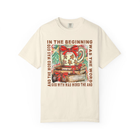 In the Beginning Tee features Christmas imagery with John 1:1 text, showcasing a festive mug, ribbon-wrapped books, and snowy pine trees on a cozy sweatshirt.
