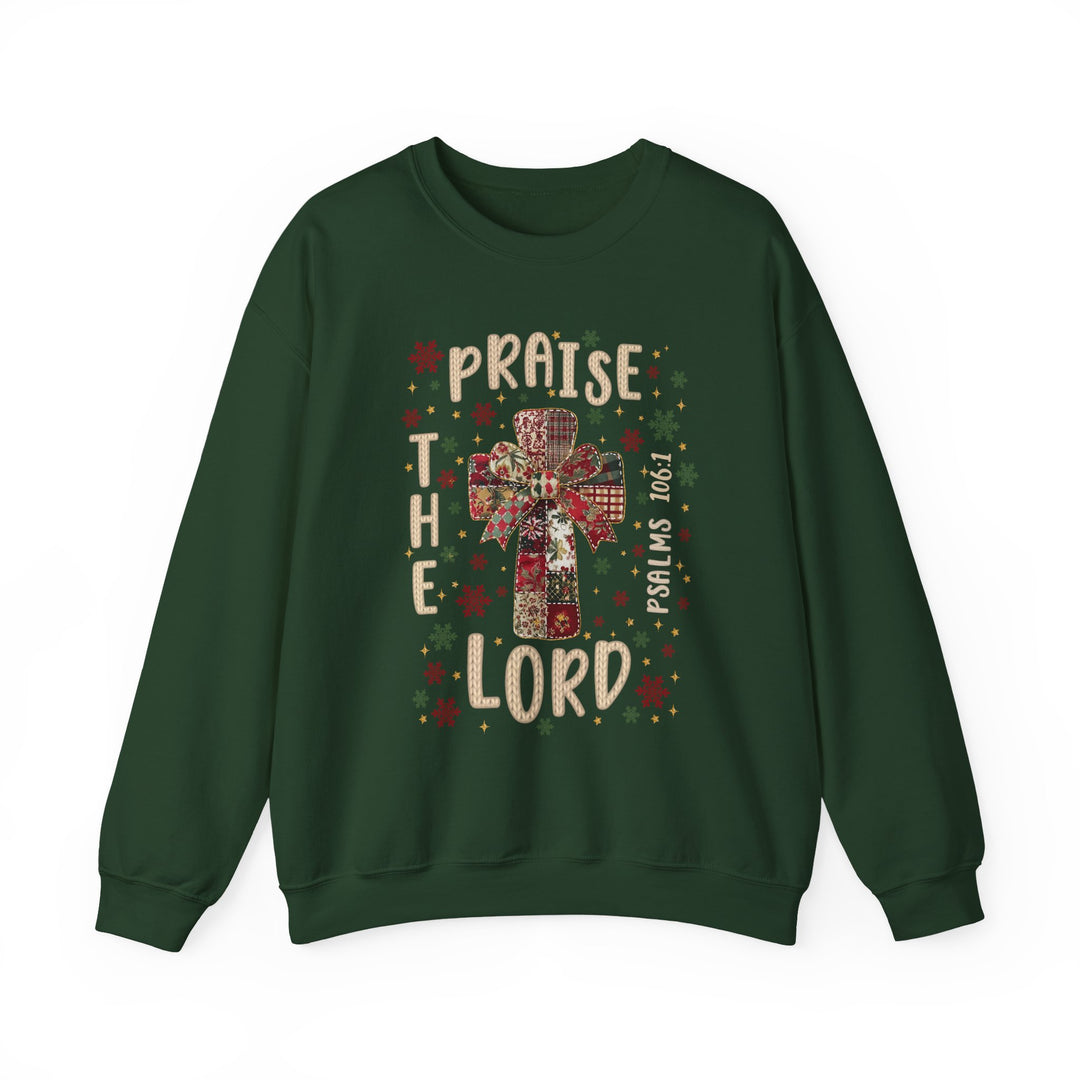 Praise the Lord Crew: Forest-green sweatshirt featuring a patchwork cross, festive bow, and Psalms 106:1, surrounded by red, green, and gold snowflakes.