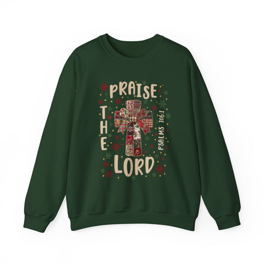 Praise the Lord Crew: Forest-green sweatshirt featuring a patchwork cross, festive bow, and Psalms 106:1, surrounded by red, green, and gold snowflakes.