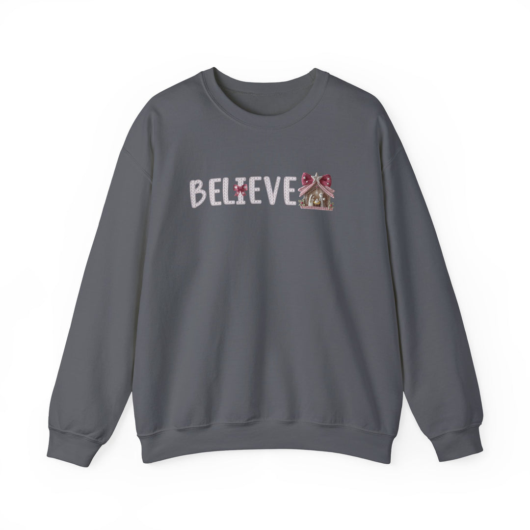 Dark-gray crewneck sweatshirt with BELIEVE in stitched letters, featuring a gingerbread-house E design. Cozy, durable, perfect for colder months. Ideal for Faith Family Designs' graphic apparel collection.