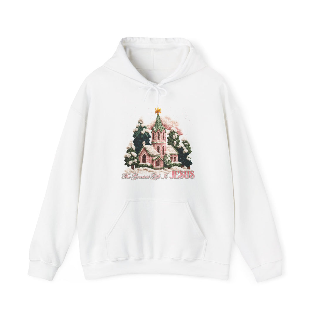 Gift is Jesus Hoodie: A cozy white pullover featuring a snow-dusted church scene with trees and star, slogan “The Greatest Gift is JESUS.” Ideal for cold days.