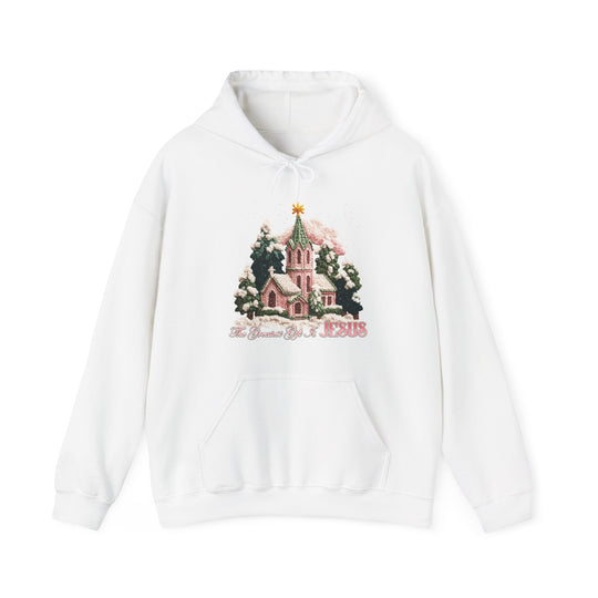 Gift is Jesus Hoodie: A cozy white pullover featuring a snow-dusted church scene with trees and star, slogan “The Greatest Gift is JESUS.” Ideal for cold days.