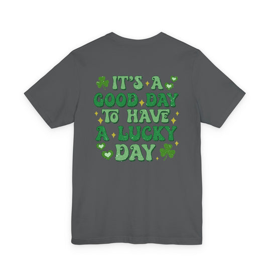 Dark gray T-shirt featuring green glitter-style text reading “It’s a good day to have a lucky day” with shamrocks and hearts, St. Patrick’s Day themed graphic