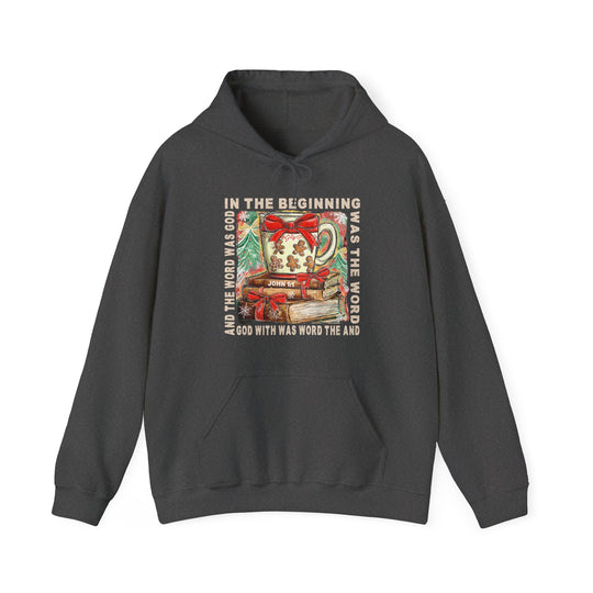 Dark-charcoal hoodie featuring a Christmas-themed graphic with a Bible verse from John 1:1, showcasing books and a festive mug, by Faith Family Designs.