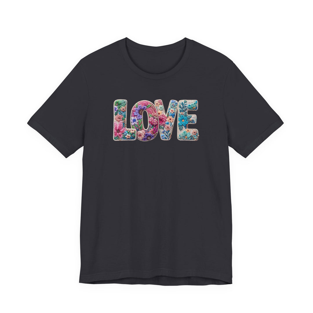 Love Spring Tee with LOVE in floral motif on charcoal T-shirt, highlighting vibrant blossoms. Unisex fit, soft cotton, ribbed collar, and durable seams.