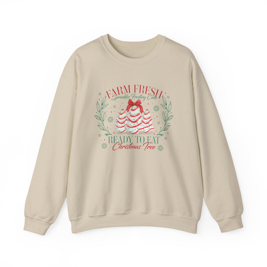 Cream-colored crewneck sweatshirt with festive Farm Fresh Cookies Crew graphic of frosting trees, red bow, wreath accents, and snowflakes. Cozy, durable, and stylish.