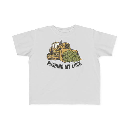 Pushing My Luck Toddler Tee featuring a yellow bulldozer graphic scooping four-leaf clovers with the caption, “PUSHING MY LUCK,” perfect for sensitive skin.