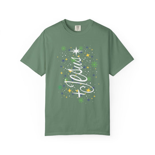 Sage-green Jesus Tree Tee featuring a festive snowflake and star graphic with a flowing cursive overlay, perfect for holiday-themed wear.