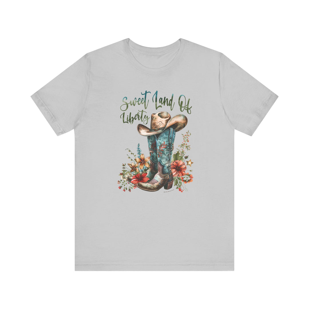 A Sweet Land of Liberty Tee featuring a cowboy hat and boots design on a white shirt. Unisex jersey tee with ribbed knit collars, 100% cotton, retail fit, tear away label. Sizes XS to 3XL.