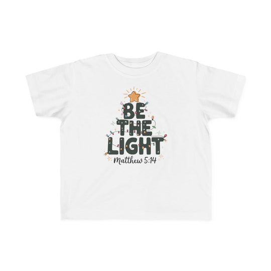 Be the Light Toddler Tee with BE THE LIGHT graphic in tree shape, adorned with Christmas lights and Matthew 5:14 reference, offers softness and durability for toddlers.