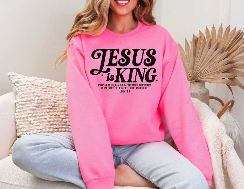 Woman smiling while wearing 'Jesus is King Crew' sweatshirt, showcasing its casual, comfortable fit, ideal for any situation.