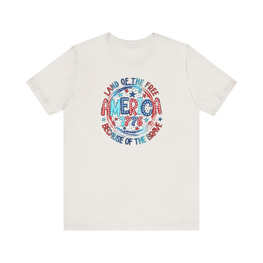 A unisex jersey tee featuring red, white, and blue text, embodying the America 1776 Tee spirit. Made of 100% cotton, with ribbed knit collars and taping on shoulders for lasting fit. Sizes XS to 3XL.