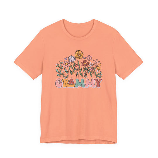 Grammy Flower Tee featuring a whimsical garden and GRAMMY in multicolored bubble letters. Retro-inspired with butterflies, this soft, unisex cotton tee offers a classic fit.