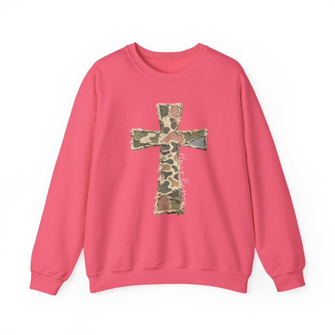 Heis Risen Cross Crew sweatshirt featuring a camo cross appliqué with cursive text He’s Risen, offering comfort with a polyester-cotton blend and ribbed collar.