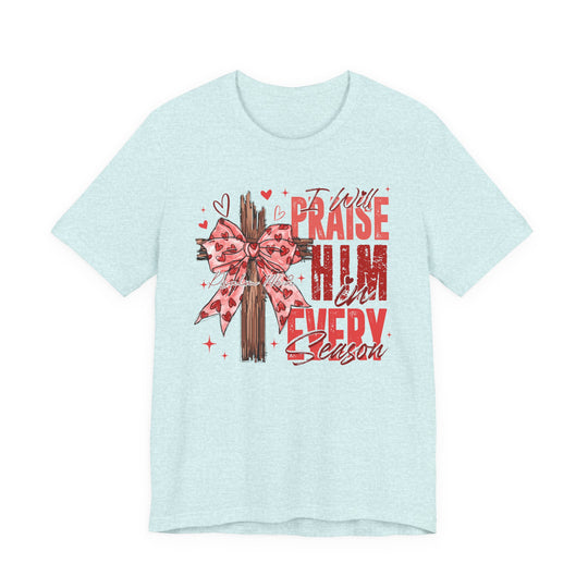Aqua T-shirt with a wooden cross and pink bow graphic, featuring the text “I Will Praise Him In Every Season” and Psalm 146:2 reference.