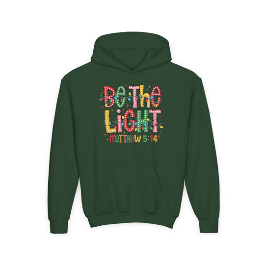 Be the Light Youth Hoodie: Festive dark green pullover with a kangaroo pocket, featuring a playful 'Be the Light' graphic with decorative Christmas lights and Bible verse Matthew 5:14.