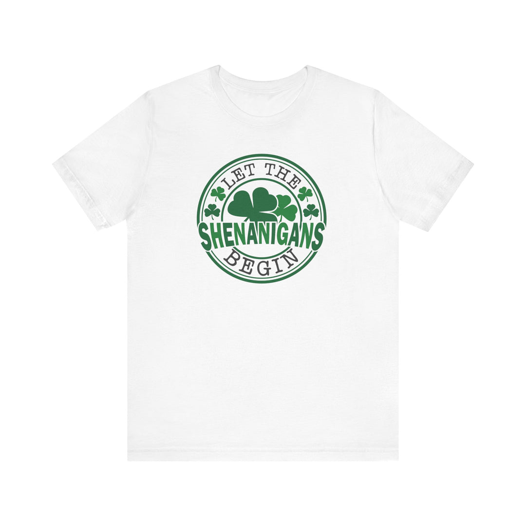 Let The Shenanigans Begin Tee features a white t-shirt with Let The Shenanigans Begin in green text, complemented by a green circle with clovers.