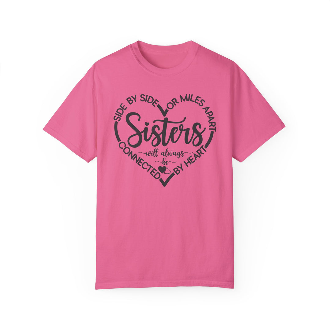Sisters At Heart Tee: A pink Gildan t-shirt featuring black text, crafted from 100% ring-spun cotton with a relaxed fit and durable double-needle stitching.