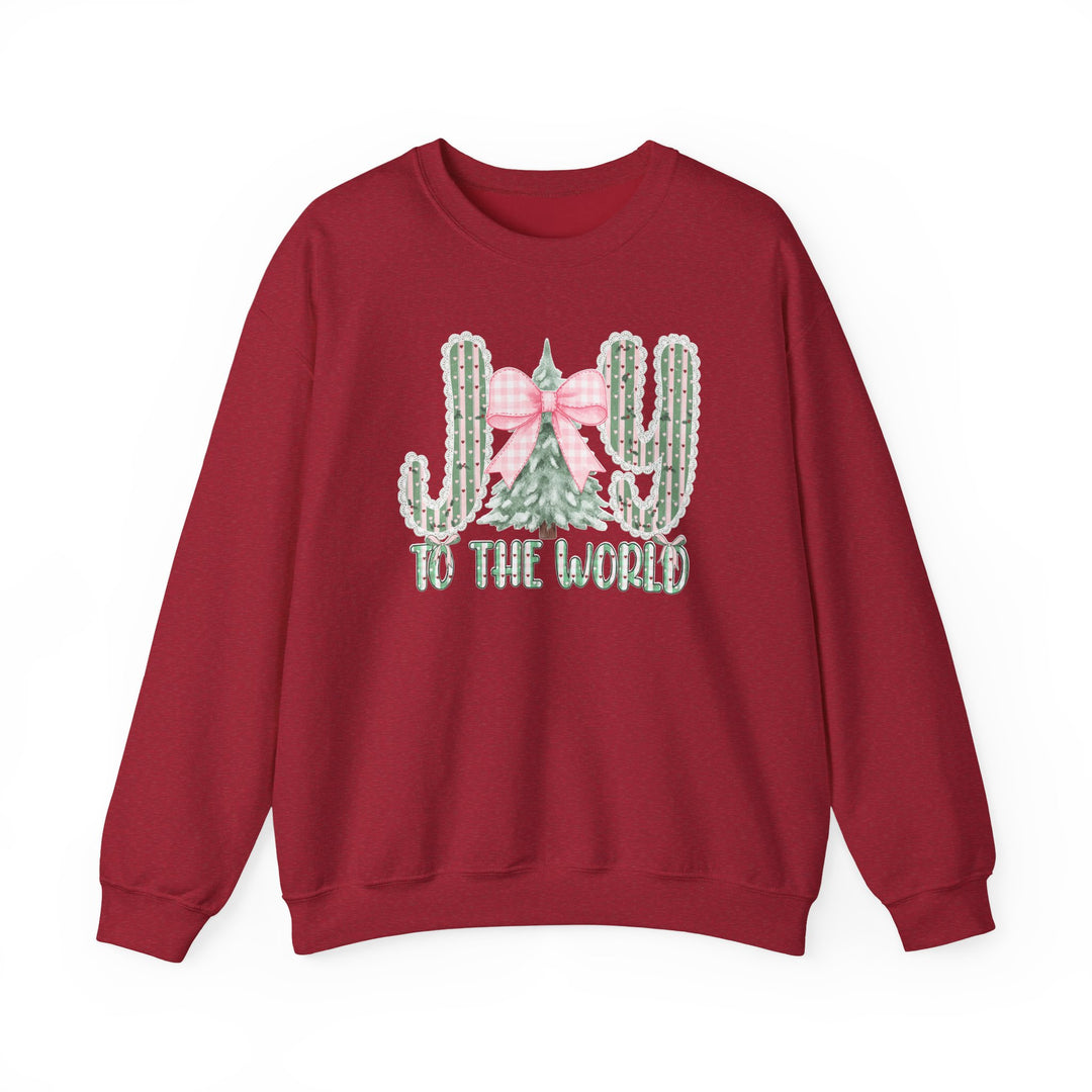 Red crewneck sweatshirt featuring a holiday graphic with cacti spelling JOY and to the world text, made from a cozy cotton-polyester blend.