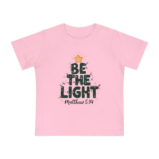 Be the Light Baby Tee featuring a Christmas tree design with BE THE LIGHT, a yellow star, and multi-colored lights, perfect for stylish, comfortable wear.