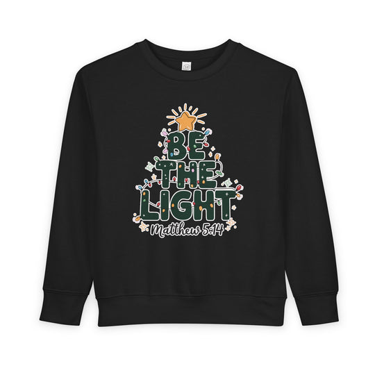 Be the Light Toddler Crew sweatshirt with festive tree graphic, Bible verse Matthew 5:14, crafted from soft, durable cotton-poly blend for comfort and style.