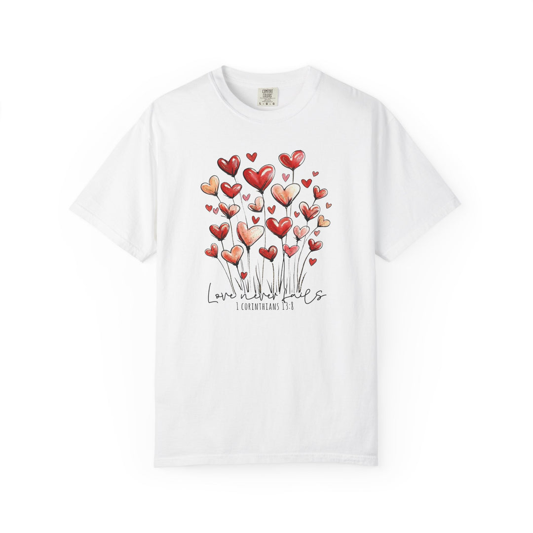 Love Never Fails Tee featuring heart-shaped balloons and 1 Corinthians 13:8 phrase, combining comfort and style, perfect for expressing timeless love through fashion.