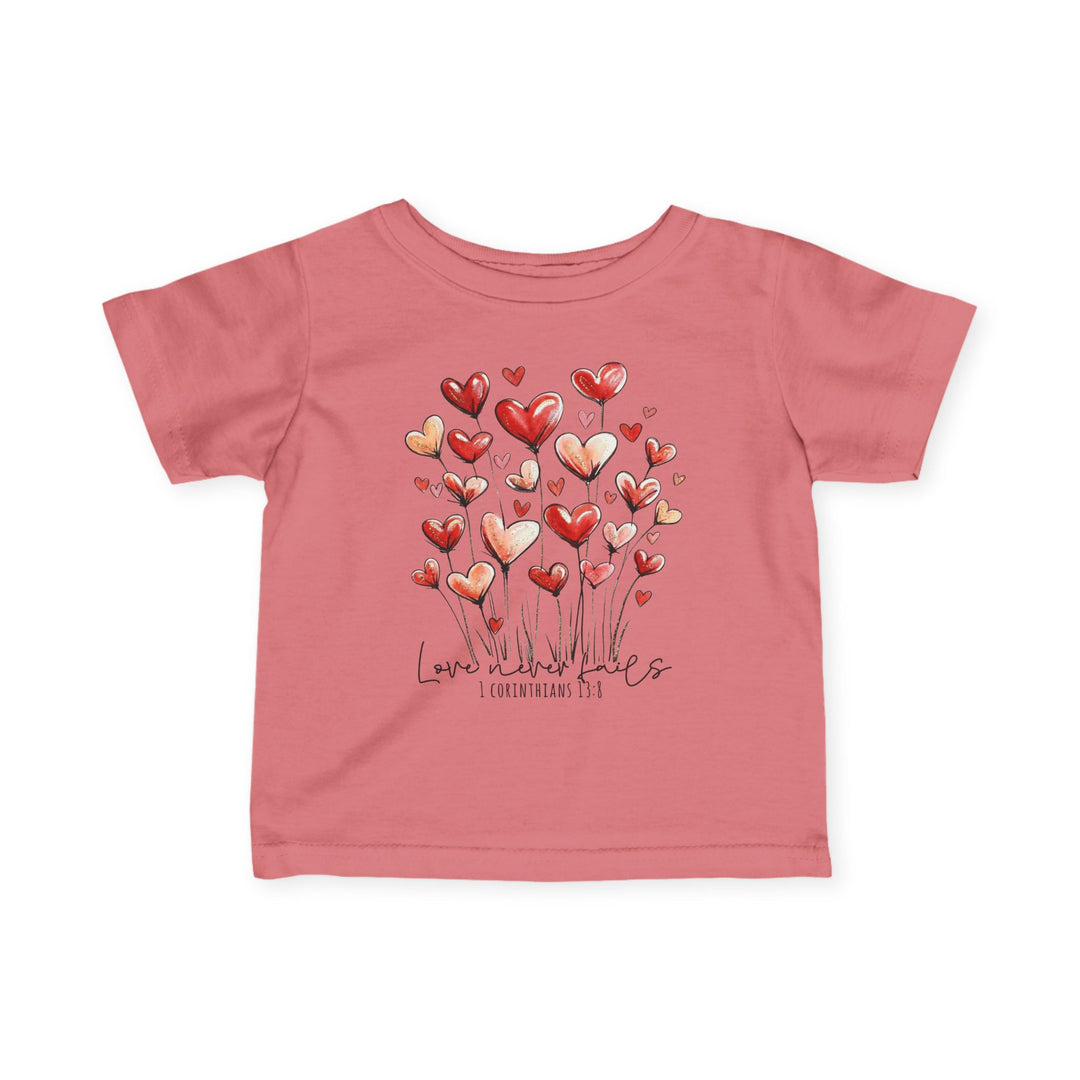Pink toddler T-shirt with heart-shaped blooms and Love never fails script, emphasizing comfort and durability.