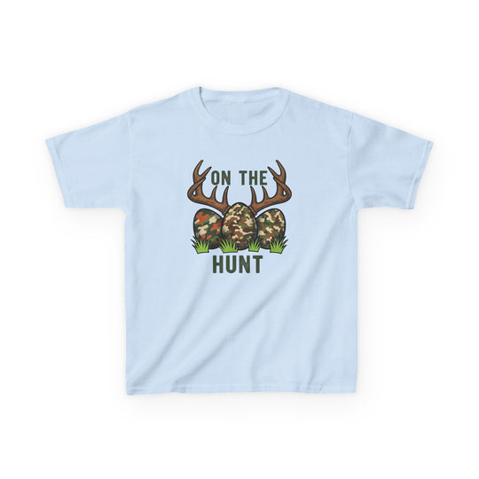 Light-blue On the Hunt Kids Tee with camo eggs, deer antlers, playful Easter-hunting graphic. Durable cotton, perfect for everyday wear.