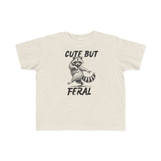 Cute but Feral Toddler Tee featuring a playful raccoon illustration with bold text, designed for comfort with soft, durable cotton, perfect for toddler adventures.