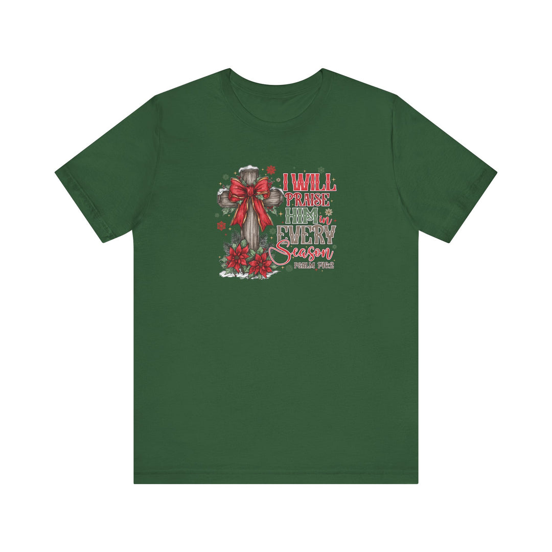 Praise Him in Every Season Tee: Forest-green T-shirt featuring a wooden cross with a red bow, poinsettias, snowflakes, and Psalm 146:2, promoting faith in every season.