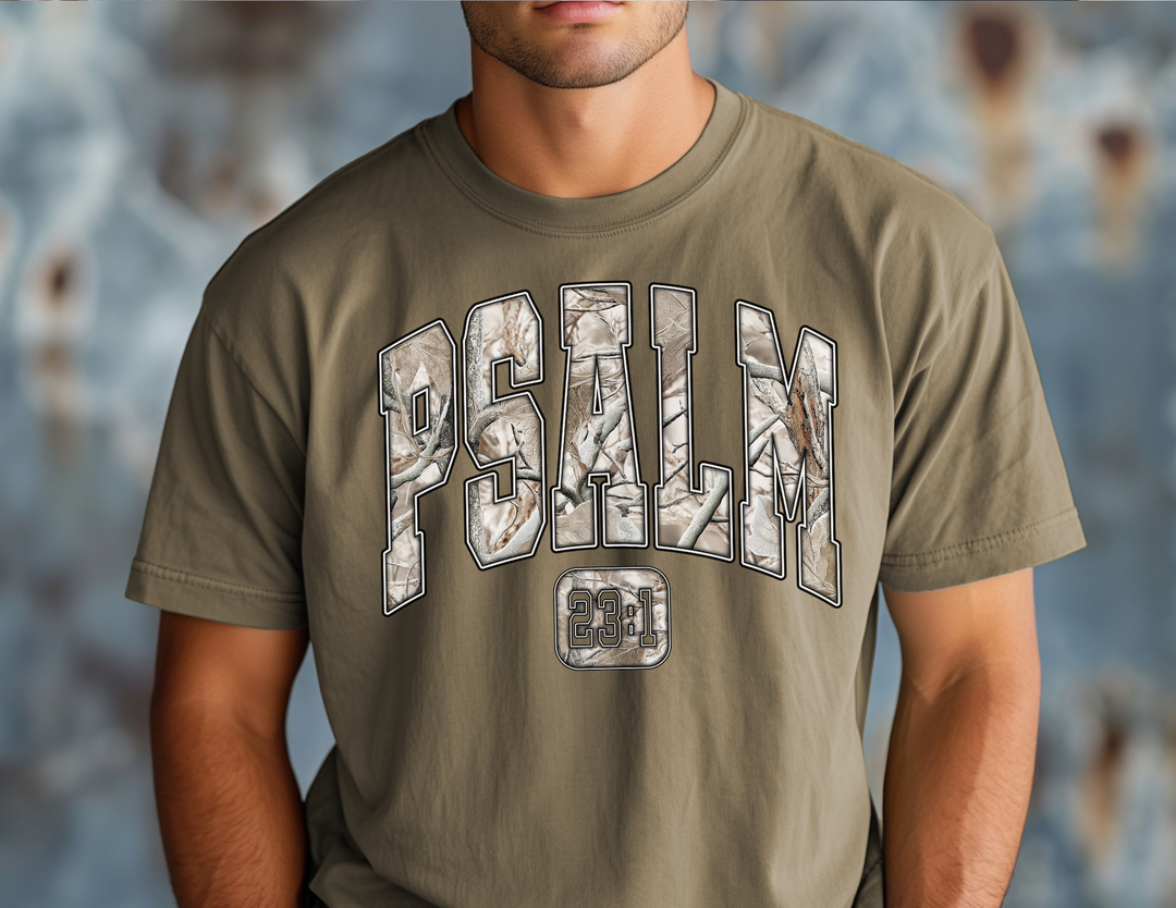 Man wearing Camo Psalm 23 Tee featuring camo-patterned PSALM text and 23:1 boxed underneath on an olive-green T-shirt from Faith Family Designs.