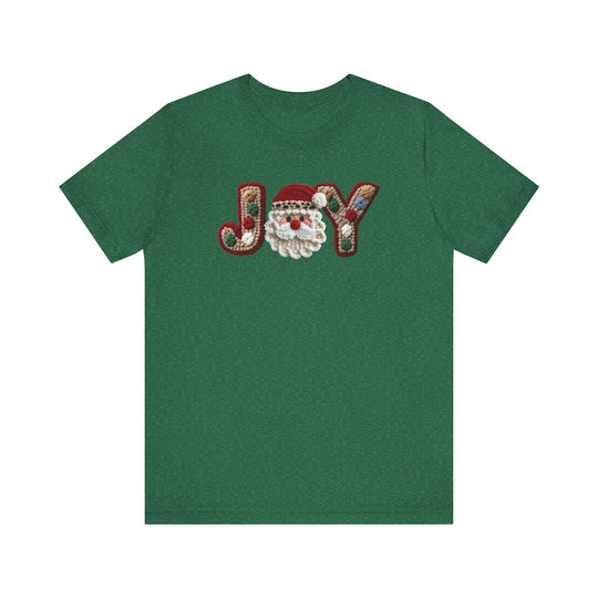 Joy Tee featuring a festive JOY design with a hooked-rug style and a Santa-face graphic, on a soft, unisex green cotton T-shirt.
