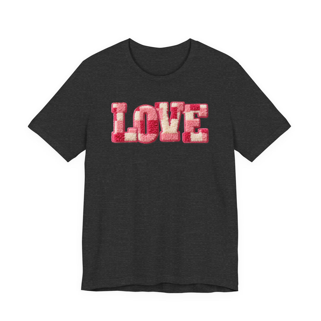 Dark-charcoal Love Tee with plush LOVE in pink and off-white chenille texture. Unisex fit crafted from soft cotton, offering comfort and style.