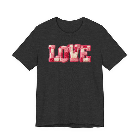 Dark-charcoal Love Tee with plush LOVE in pink and off-white chenille texture. Unisex fit crafted from soft cotton, offering comfort and style.