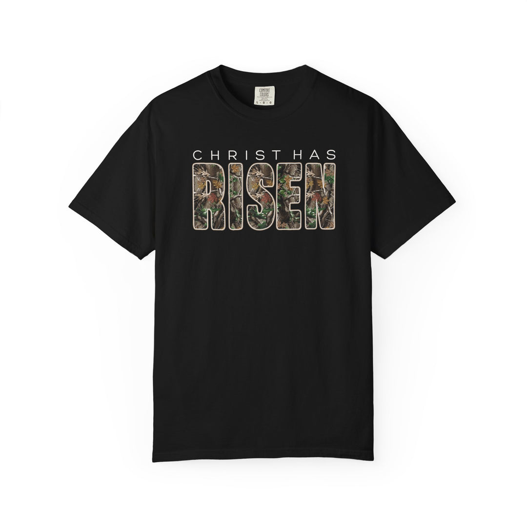 Black tee with CHRIST HAS RISEN in camo design, emphasizing faith and style, from Faith Family Designs. Available in various sizes for a relaxed fit.