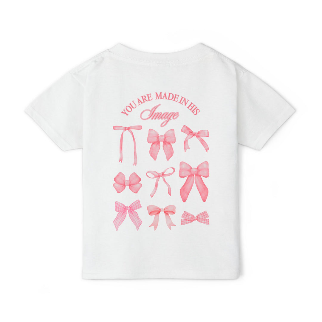 Heavy Cotton™ Toddler T-shirt featuring back print of nine pink bows and YOU ARE MADE IN HIS Image. Ideal for comfort and style.