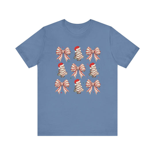 Cookies and Bows Tee: Light-blue T-shirt featuring holiday motifs of bows and cookie Christmas trees in a 3x3 grid, with stars scattered around. Classic fit.