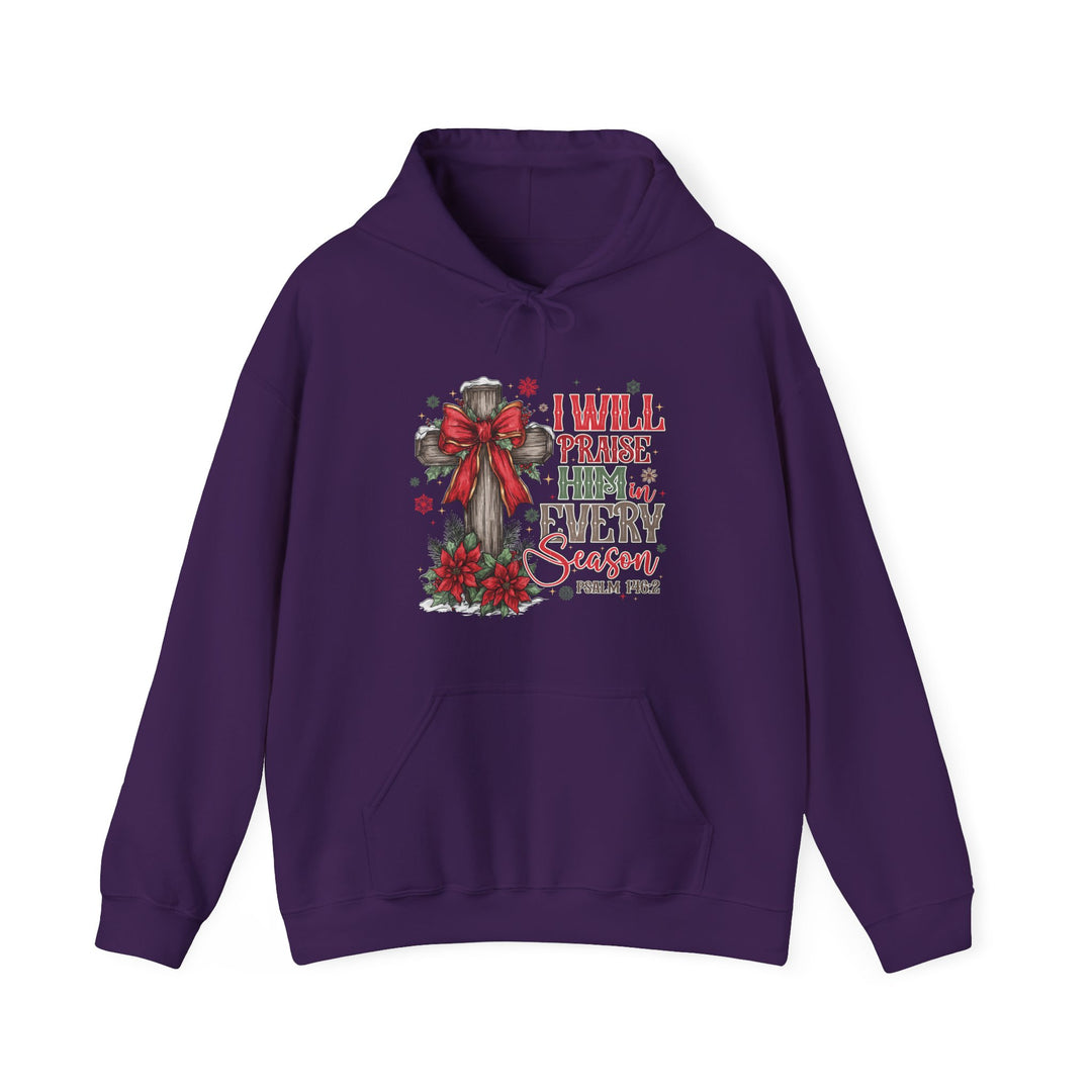 Purple Praise Him in Every Season hoodie featuring a rustic wooden cross with a red bow, poinsettias, and snowflakes, promoting warmth and faith.